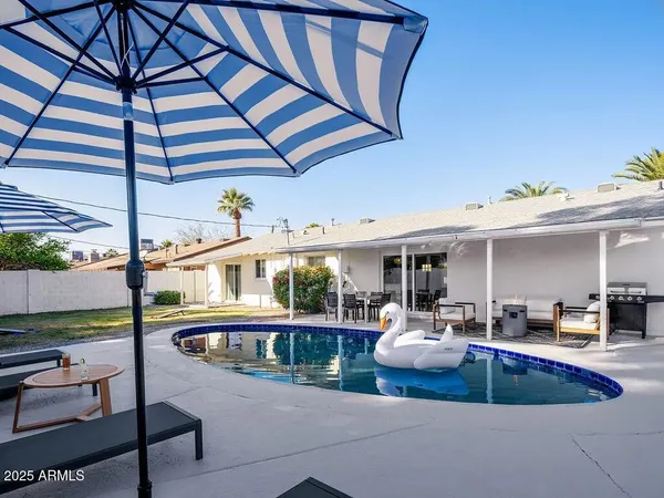 a view of a patio with a table and chairs under an umbrella