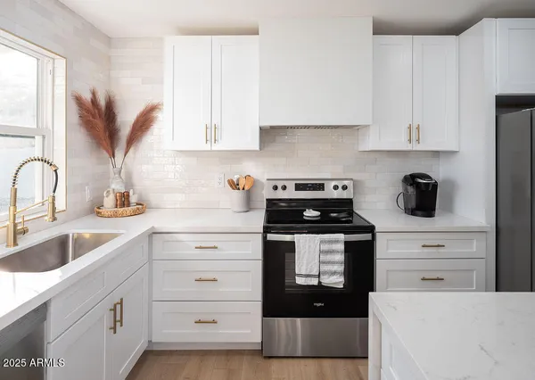 a kitchen with cabinets appliances a sink and a window