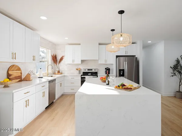 a kitchen that has a lot of cabinets and stainless steel appliances