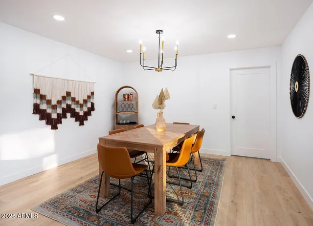 a dining room with furniture a chandelier and wooden floor