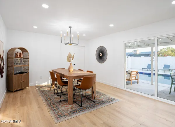 a dining room with wooden floor and chandelier