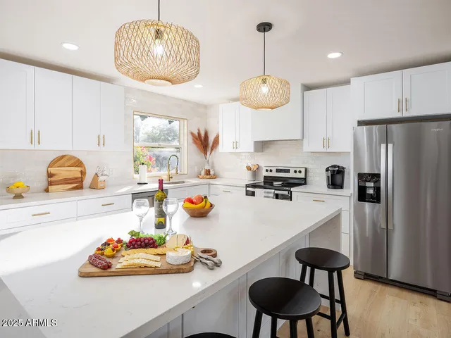 a kitchen with a refrigerator and a stove next to a window