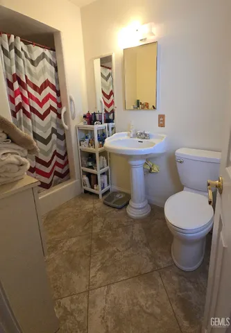 a bathroom with a toilet sink and mirror