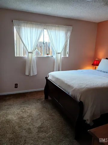 a bed sitting in a bedroom next to a window