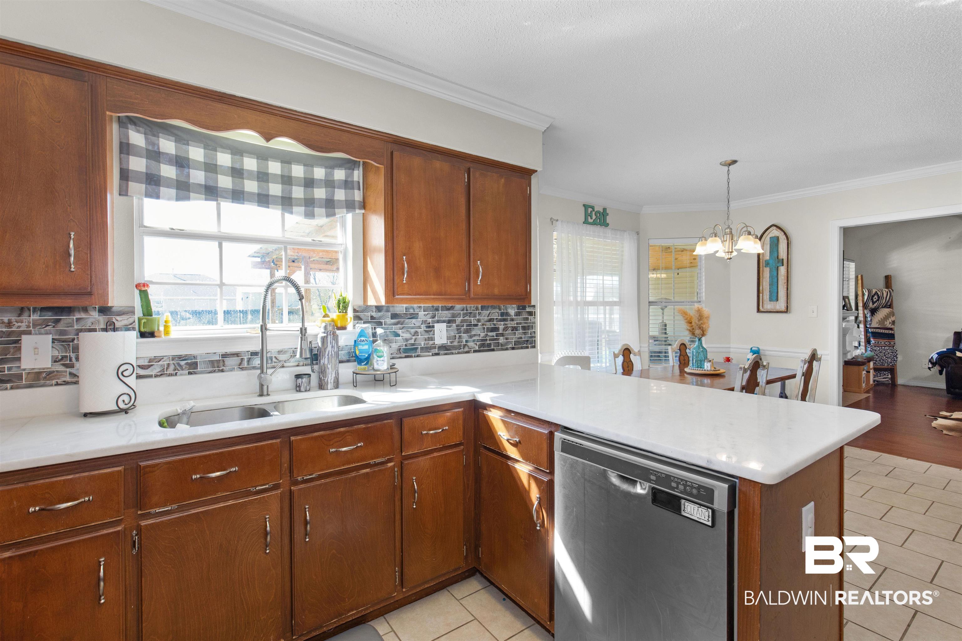 4950 Clealand Court Mobile, AL 36695 - Photo 8 of 20 Kitchen featuring a peninsula, stainless steel dishwasher, a sink, and light countertops