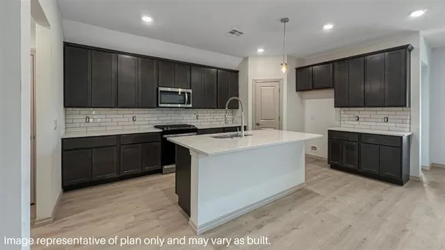 a kitchen with a sink cabinets and stainless steel appliances