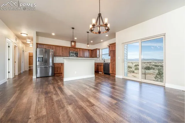 a view of a kitchen with refrigerator and wooden floor