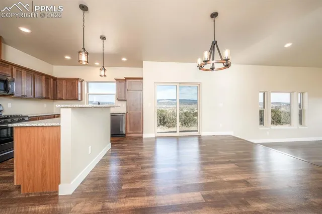 a kitchen with stainless steel appliances granite countertop a refrigerator oven a sink dishwasher and a refrigerator with wooden floor