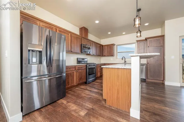 a kitchen with stainless steel appliances granite countertop sink stove and refrigerator