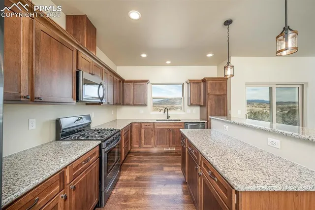 a kitchen with stainless steel appliances a stove a sink and a microwave
