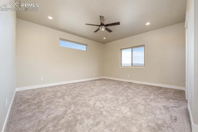 an empty room with closet and a ceiling fan
