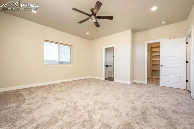 an empty room with closet and windows