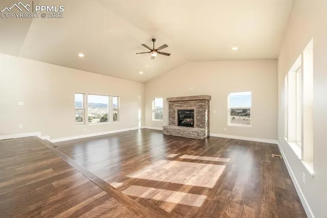 a view of an empty room with window and wooden floor