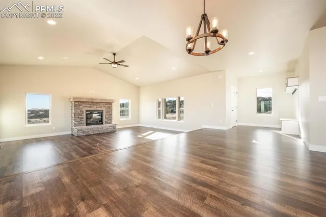 a view of a livingroom with a fireplace a chandelier and wooden floor