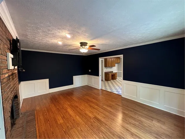 an empty room with a ceiling fan and window