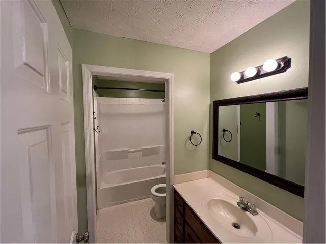 an empty room with a window and chandelier fan