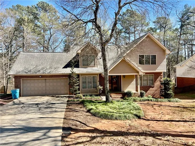 a front view of a house with a yard and potted plants