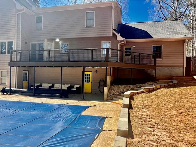 an aerial view of a house with outdoor space and trees all around