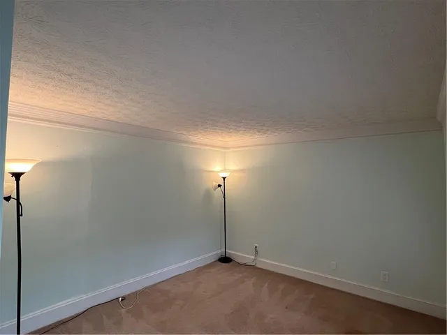 a white toilet sitting next to a white wall