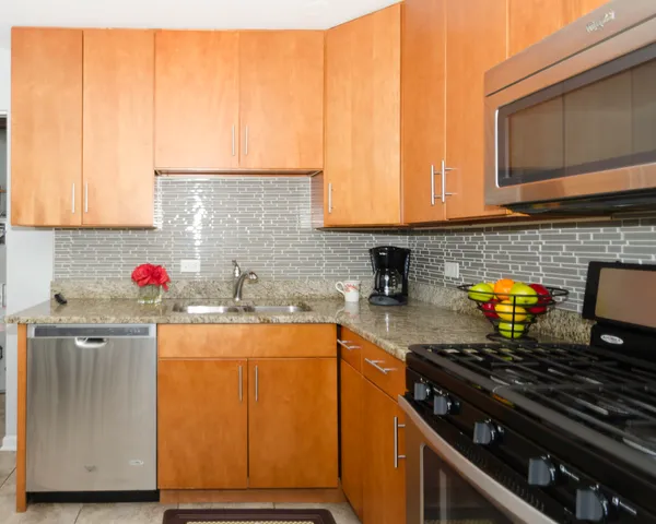 a kitchen with granite countertop a sink stove and cabinets
