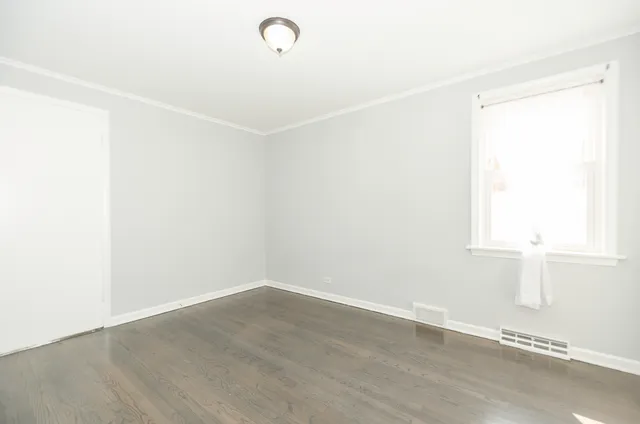 a view of a small space with wooden floor and a window