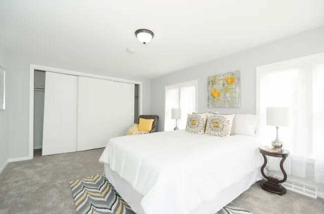 a bedroom with a bed and painting on the wall