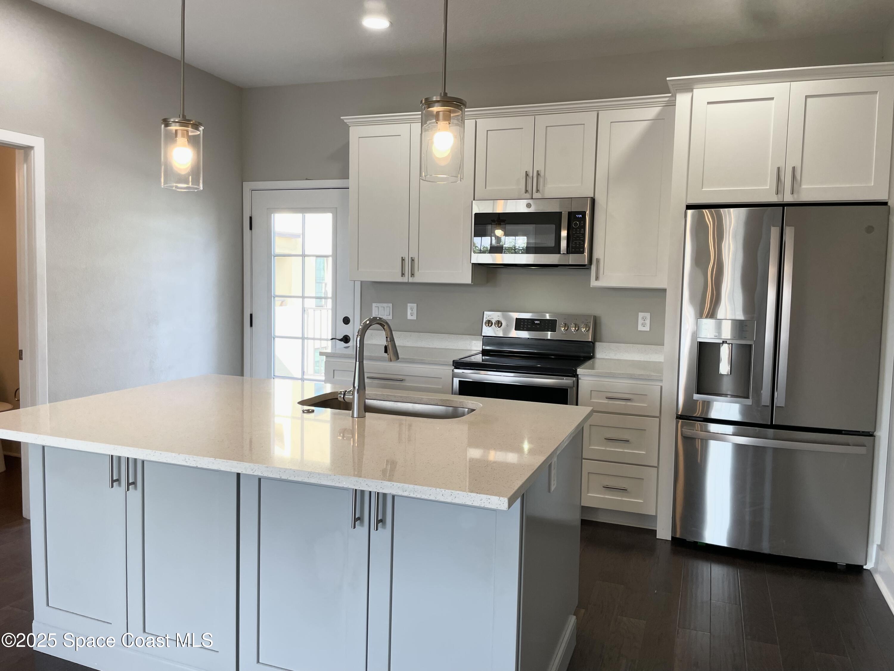 890 Florida Avenue Cocoa, FL 32922 - Photo 12 of 63 a kitchen with stainless steel appliances a refrigerator sink and microwave
