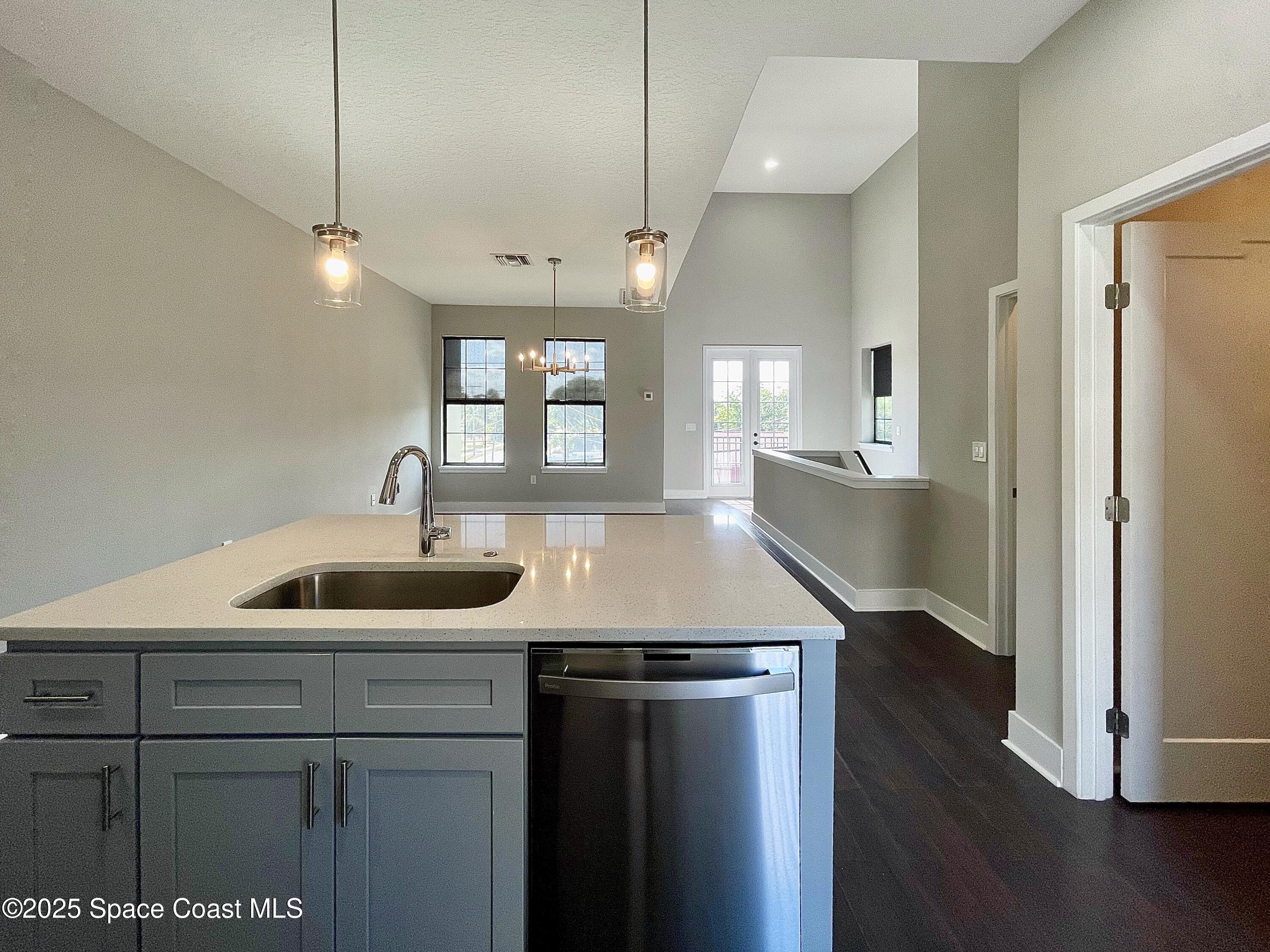 890 Florida Avenue Cocoa, FL 32922 - Photo 45 of 63 a kitchen with stainless steel appliances granite countertop a sink a refrigerator and wooden floor