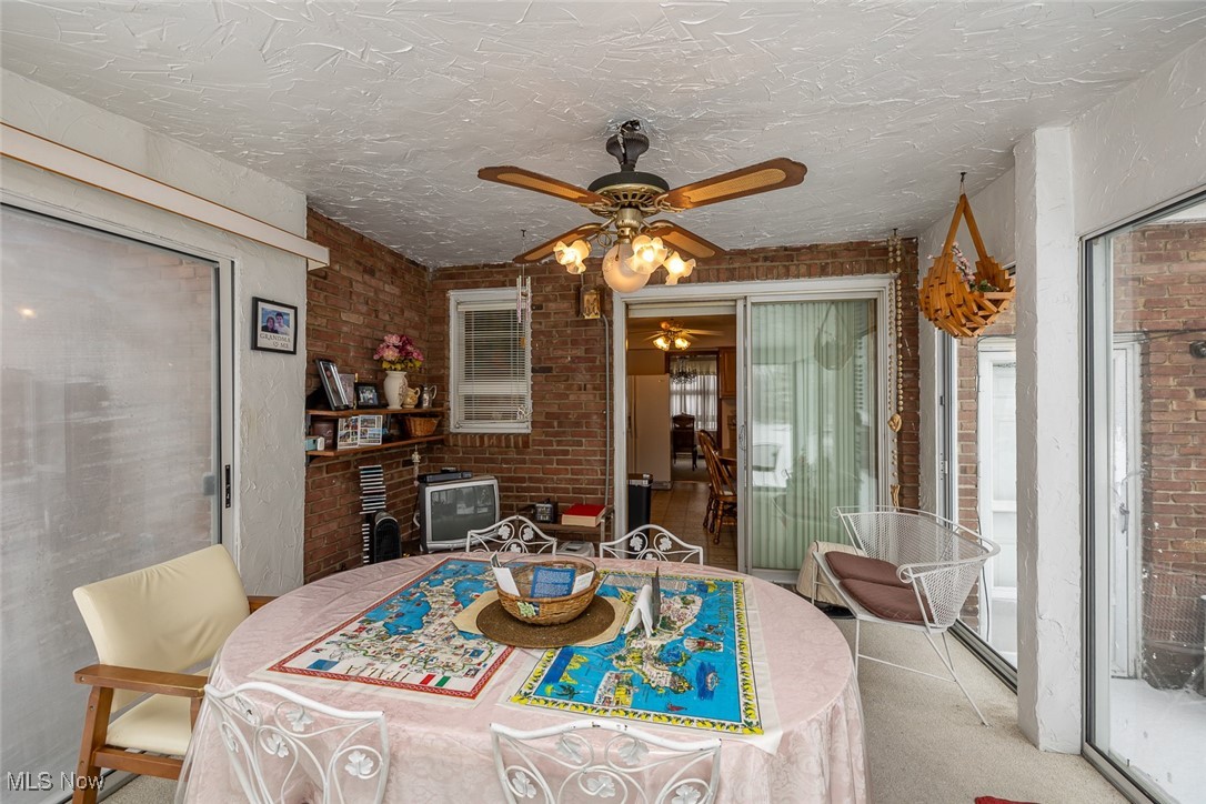 750 Sagamore Road Northfield, OH 44067 - Photo 15 of 37 View 3 Carpeted dining area with ceiling fan, brick wall, and a textured ceiling