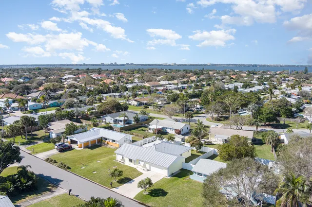 an aerial view of a city with lots of residential buildings and mountain view in back