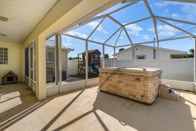 a view of a patio with table and chairs under an umbrella