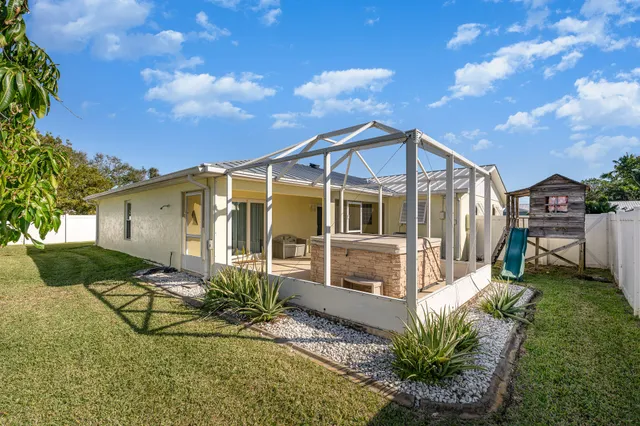 a view of a backyard with plants and large tree