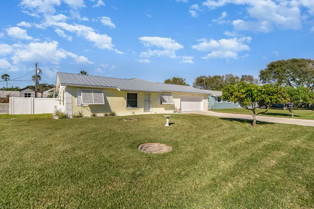 a view of a white house with a yard