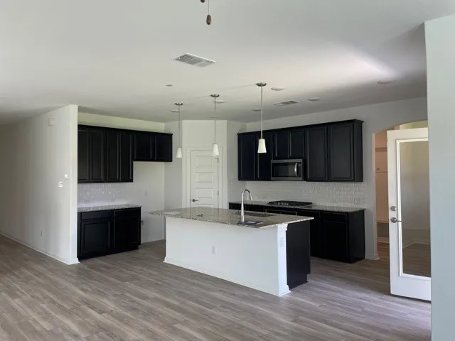 a kitchen with granite countertop a sink a stove and cabinets