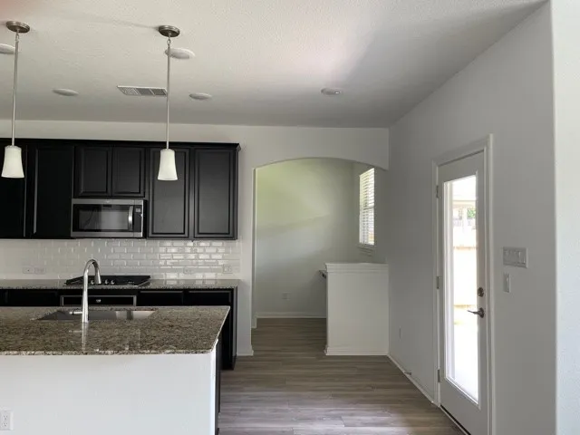 a kitchen with stainless steel appliances granite countertop a sink and a microwave