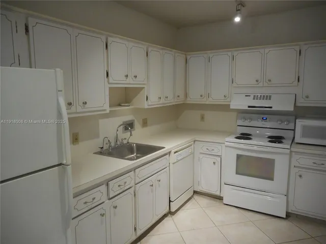 a kitchen with white cabinets and white appliances