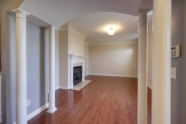 a view of a livingroom with wooden floor a fireplace and windows