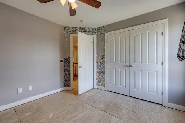 an empty room with chandelier fan