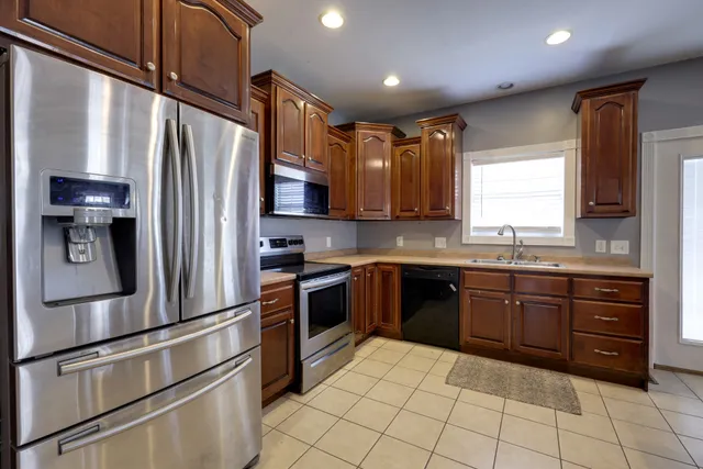 a kitchen with stainless steel appliances granite countertop a refrigerator and a stove top oven