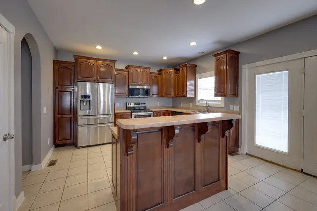 a kitchen with stainless steel appliances granite countertop a refrigerator and a stove top oven