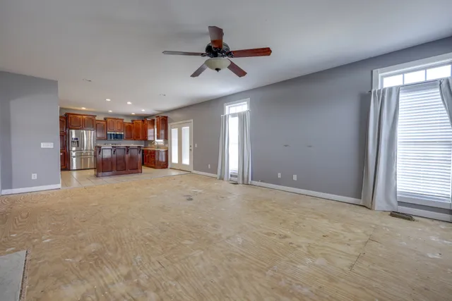a view of a livingroom with a ceiling fan and window