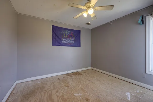 an empty room with a window and a fan