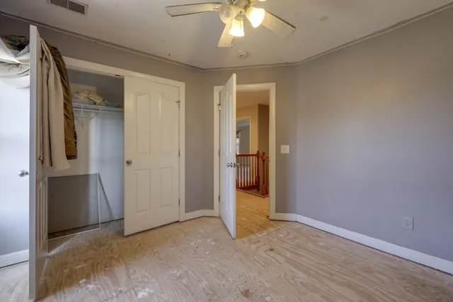 an empty room with closet and a hallway