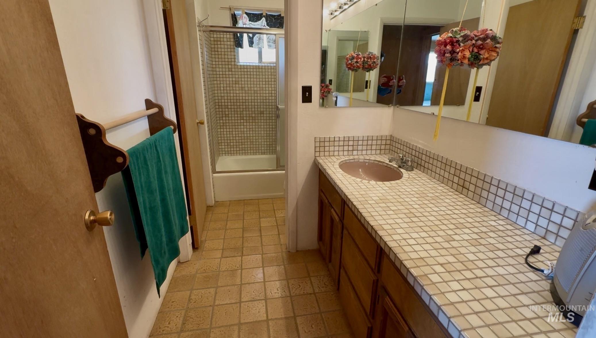 2040 Pahsimeroi River Road May, ID 83253 - Photo 16 of 29 Bathroom featuring a vanity with a tiled countertop, integrated sink, and wood cabinetry