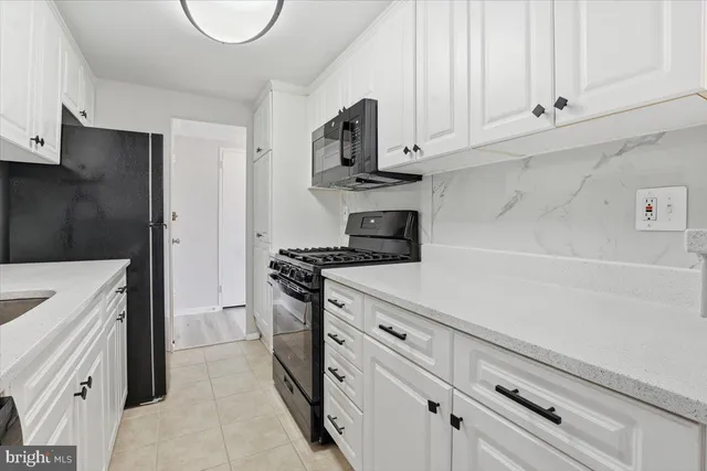 a kitchen with stainless steel appliances a sink a stove and cabinets