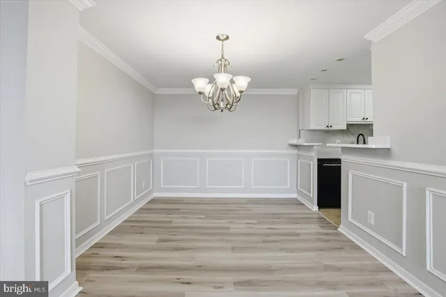 a kitchen with stainless steel appliances granite countertop a white cabinets a stove top oven and chandelier