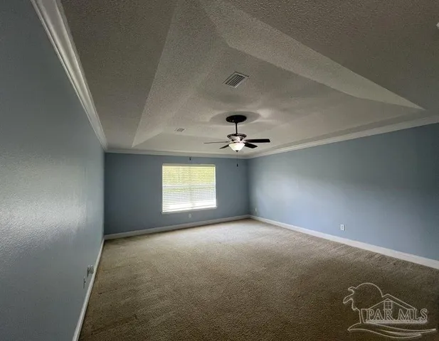 an empty room with windows and ceiling fan
