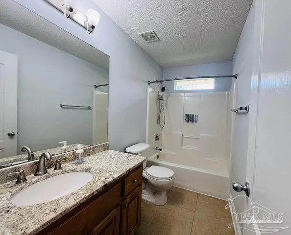 a bathroom with a granite countertop sink a toilet and shower