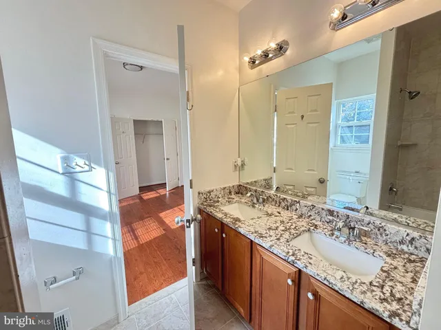 an empty room with wooden floor and closet area