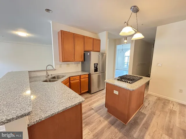 a kitchen with stainless steel appliances granite countertop a sink a stove and refrigerator